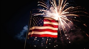 Picture of an American flag with fireworks behind it